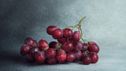 Fresh Red Grapes Bunch on Textured Grey Background