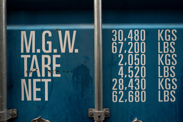 Generic, standard shipping container showing weight measurements on one of the metal doors. The...