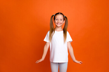 Photo portrait of cute little lady cute charming cheerful posing dressed stylish striped garment isolated on orange color background