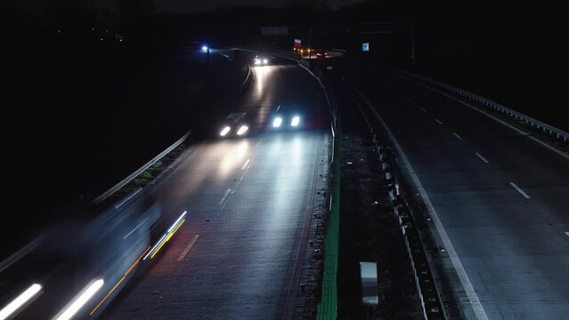Light trails on the highway at night. Rush hour on motorway with glowing cars headlamps, timelapse