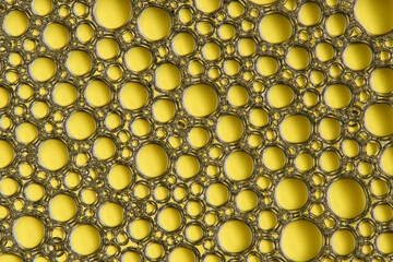 Abstract yellow macro background with lots of soap bubbles.