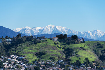 Snow capped Mt Baldy peak with the Los Angeles Mt Washington hillside neighborhood in foreground.   