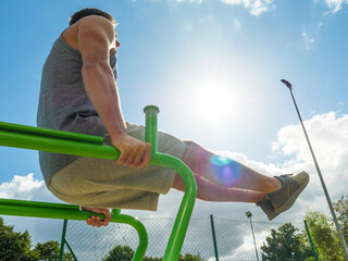 Man doing legs exercises in outdoor gym