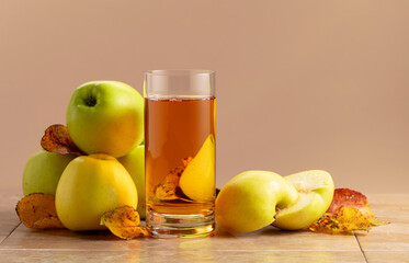 Apple juice and ripe apples with dried-up leaves.