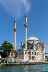 Fototapeta na wymiar Ortakoy Mosque on the banks of the Bosphorus on summer day. Amazing masterpiece of Ottoman baroque, XIX century. Tourism or architecture concept. June 16, 2022. Istanbul, Turkey (Turkiye)