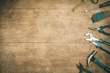 Assorted Hand Tools Laid Out on wooden background, top view with space for text