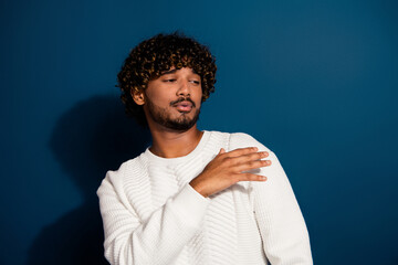 Portrait of young handsome guy hand touch shoulder cool narcissistic wearing white pullover isolated on dark blue color background