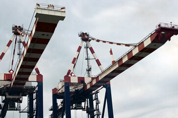 Detailed view two crane bridges for unloading or loading containers to the cargo freight ship from port area. Import, export and business logistic. International water transport