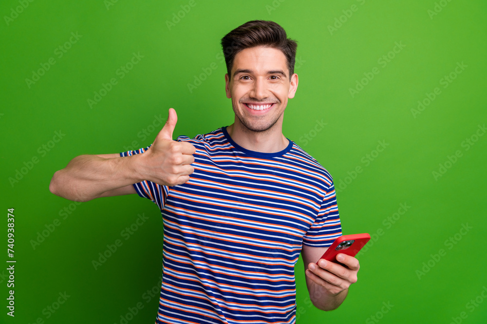 Canvas Prints photo of handsome positive man toothy smile hold smart phone demonstrate thumb up isolated on green 