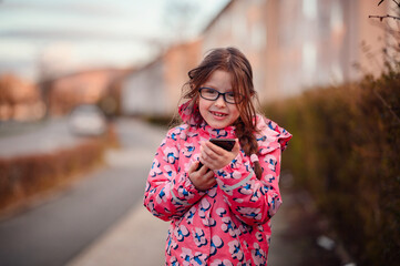 Delighted Young Girl Using Smartphone Outdoors with Excitement