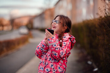 Fototapeta premium Delighted Young Girl Using Smartphone Outdoors with Excitement