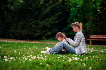 Tender moment between mother and daughter in a serene park setting