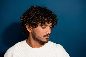 Closeup photo of young guy in white jumper showing perfect curls haircut well groomed stubble isolated on dark blue color background