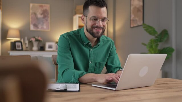 man adult caucasian WITH BEARD AND EYEGLASSES work on laptop at home