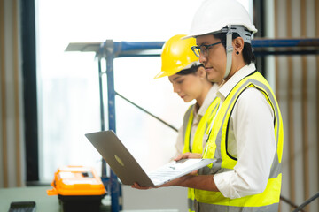 Construction engineer with technician designer team working build site inspect for interior renovate in industry workshop building with floor plan.