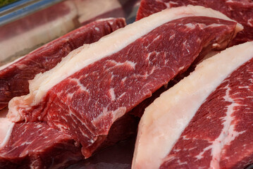 Barbecue picanha meat, raw and sliced ​​close-up.