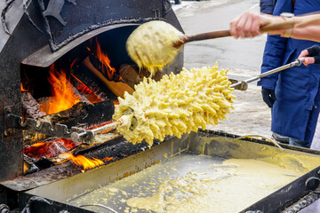 The traditional Lithuanian Polish spit cake is baked on a open fire at fair, Shakotis or spruce pie