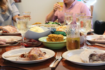 a wooden table topped with plates and bowls of food and drinks
