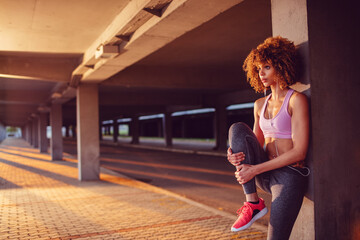 Young woman stretching before exercising and jogging in a parking lot