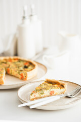 French quiche lauren with salmon, cheese and broccoli on white table. Soft focus