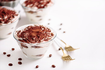 Traditional Italian dessert tiramisu in glasses on white table. Soft focus