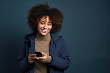 Fototapeta na wymiar Happy African American woman with phone on Navy studio background