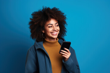 Fototapeta na wymiar Happy African American woman with phone on Sapphire studio background