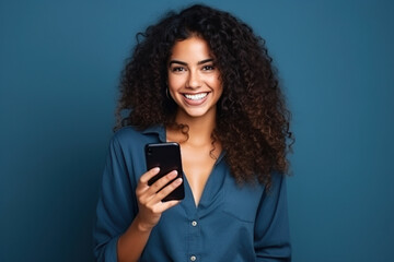 Fototapeta na wymiar Happy Latin American woman with phone on Navy studio background