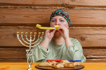 A Jewish woman with a kisuyi rosh whistles and claps at the women's celebration of the Purim
