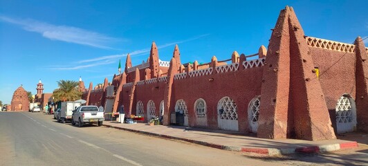 Fototapeta na wymiar Street view of the beautiful architecture made of red clay in the city of Timimoun, Algeria
