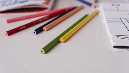 colorful pencils and coloring sheets on the table