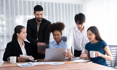 Multiracial analyst team use BI dashboard data to analyze financial report on meeting table. Group of diverse business people utilize data analysis by FIntech for success business marketing. Concord