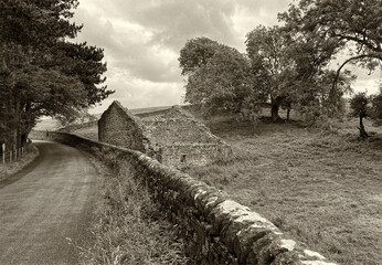 Yorkshire Dales scene, with a country road, dry stone walls, and a stone ruin near, Airton,...