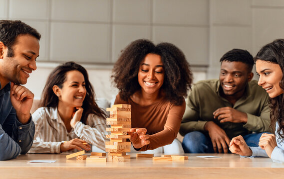 students group around table in kitchen engaging in board game