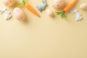 Playful Easter ambiance. Top view snapshot of decorative rabbits, a collection of eggs, and carrots for bunnies laid out on a soft beige background with space for text