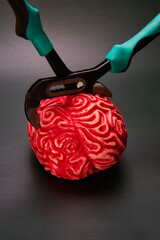 Red brain compressed by pliers. Concept of mental stress.