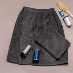 Dark gray bath terry kilt and towel. Embroidery on bath products. Square