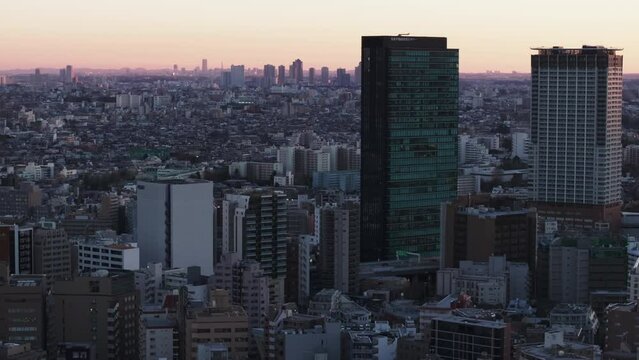 Cityscape at dusk. Aerial footage of large city with high rise office or residential towers. Twilight sky. Tokyo, Japan