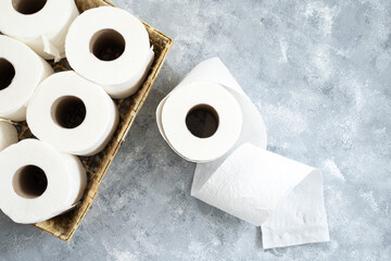 Basket with rolls of toilet paper on marble table background