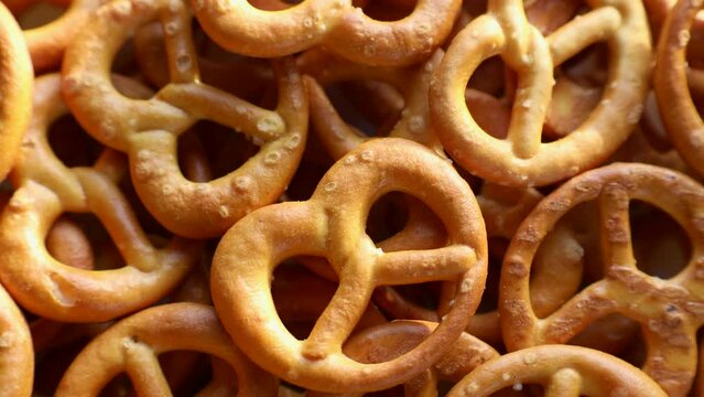 Crunchy German pretzel cracker cookies with salt crystals circle rotation close up top view