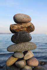 Balance pebble stone in the stoned beach at sunset. Stack of zen stones in harmony and balance with sea view. minimalist view of a perfectly stacked arrangement of pebbles on serene beach