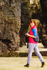 Woman with camera at Cathedral Beach, Galicia Spain.