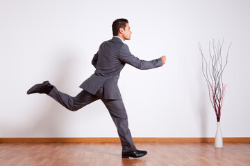 Young businessman running inside the office - 741016149