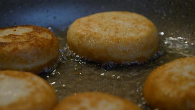 Georgian dish Chadi donuts being cooked in a boiling oil pan, close-up view.