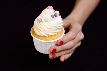 Hand holds a bright cake