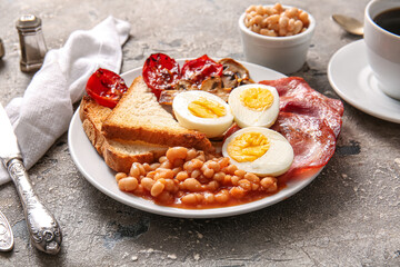 Plate of tasty English breakfast with boiled eggs on grey background