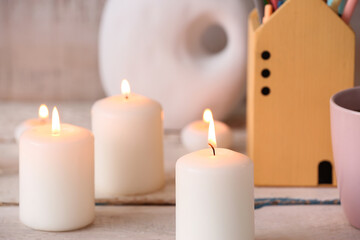 Burning candles on white wooden background