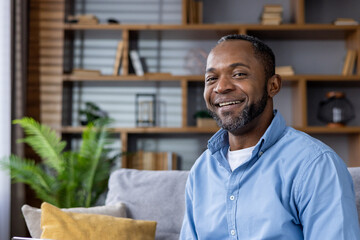 Portrait of a smiling black man relaxing at home with a stylish interior decor