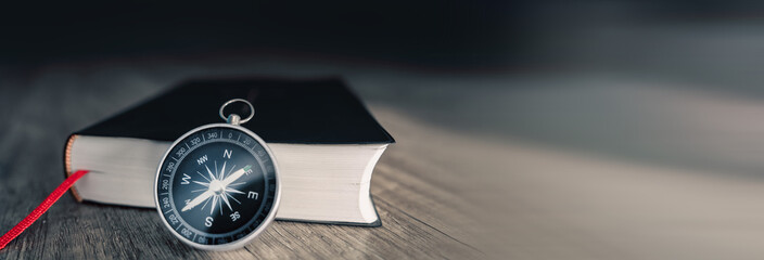 Book and compass on the table