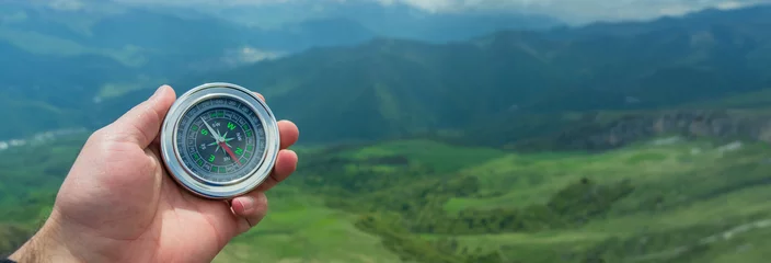 Fototapeten Khaki Holds a compass in his hand  © Daniel